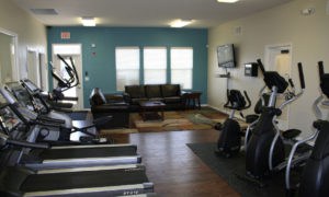 View of our fitness center with aerobic equipment like treadmills and ellipticals at our Lawrence apartments.