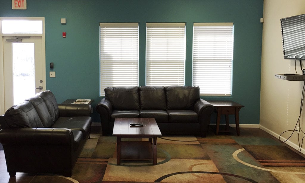 Fitness Room view with leather couch in common area at Remington Square Apartments in Lawrence